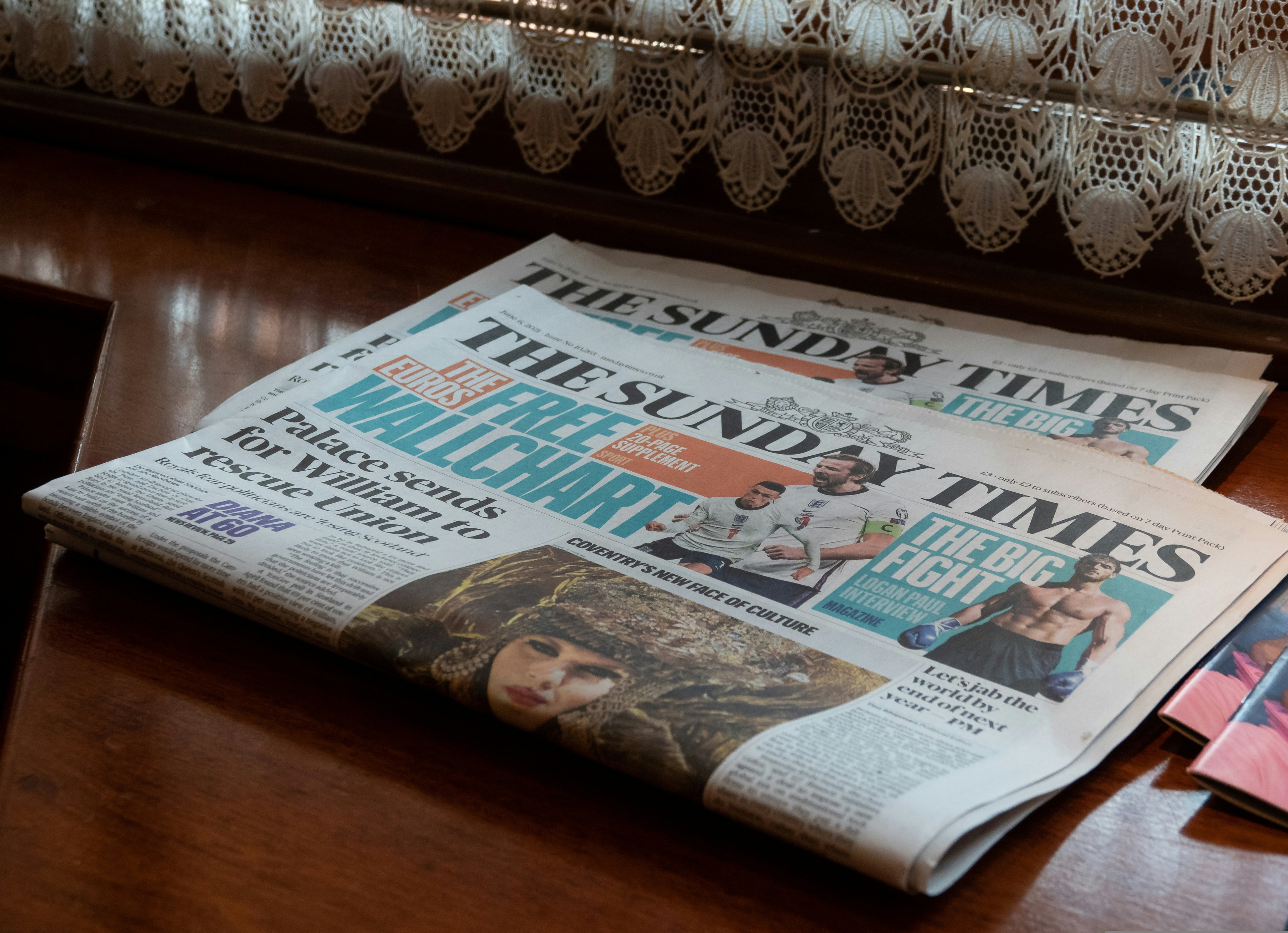 Uma banca de jornal aberta sobre uma mesa de madeira